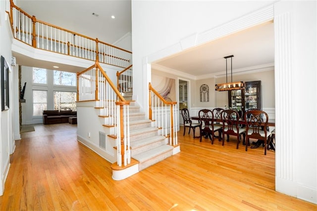 1105 River Laurel Dr, Suwanee, GA 30024 - stairs with wood finished floors, crown molding, a chandelier, and a high ceiling