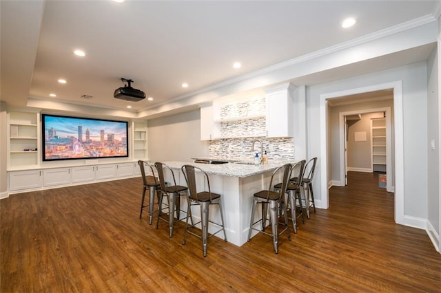 1105 River Laurel Dr, Suwanee, GA 30024 - home theater room featuring dark wood-type flooring, ornamental molding, wet bar, recessed lighting, and baseboards
