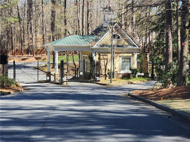 1105 River Laurel Dr, Suwanee, GA 30024 - view of asphalt street featuring a gate, curbs, and a wooded view