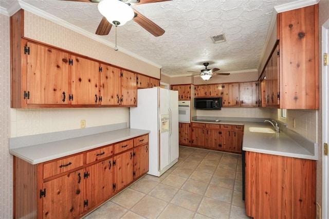 kitchen with a sink, visible vents, black appliances, and light countertops