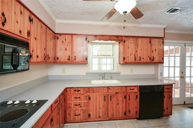 kitchen featuring visible vents, black appliances, a sink, wallpapered walls, and light countertops