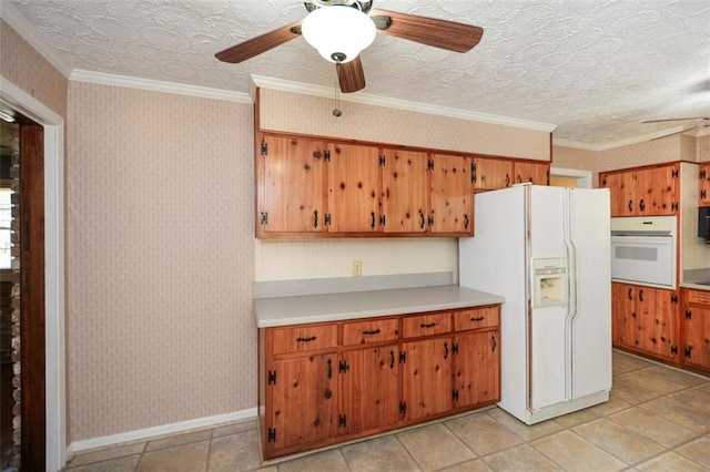 kitchen featuring wallpapered walls, white appliances, light countertops, and ornamental molding