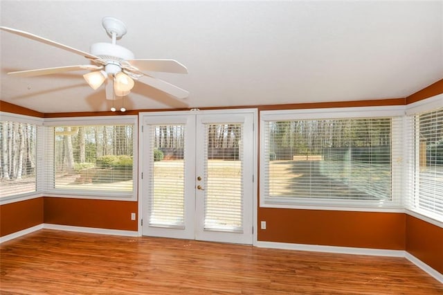 unfurnished sunroom with a ceiling fan and a wealth of natural light