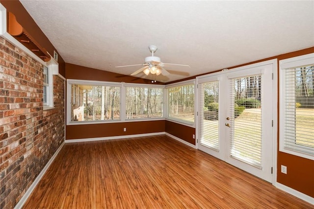 unfurnished sunroom featuring a ceiling fan