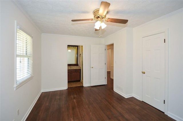 unfurnished bedroom featuring ornamental molding, a textured ceiling, baseboards, and wood finished floors