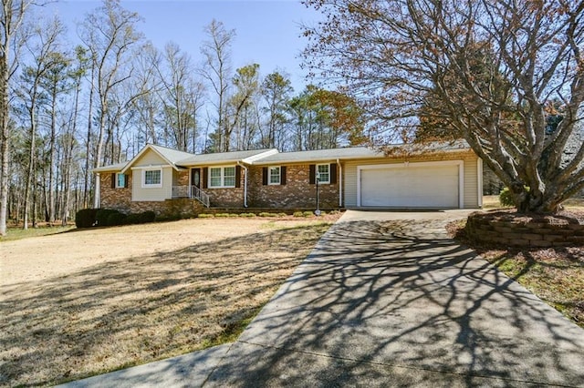 single story home featuring brick siding, a garage, and driveway