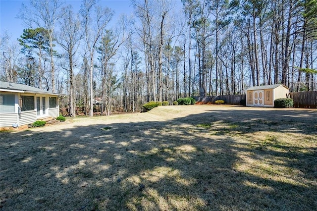 view of yard featuring entry steps, a storage shed, an outdoor structure, and fence