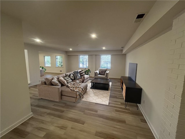 living room with light wood-type flooring, visible vents, and plenty of natural light