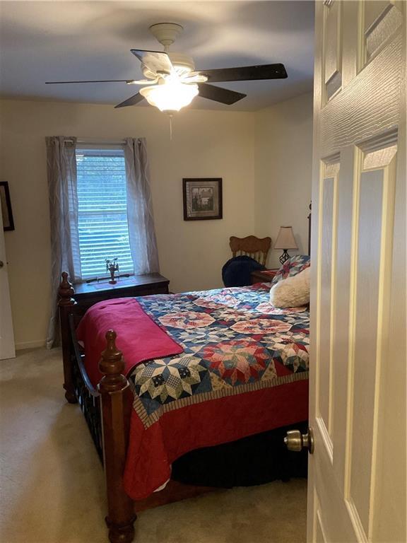 bedroom featuring ceiling fan and light carpet