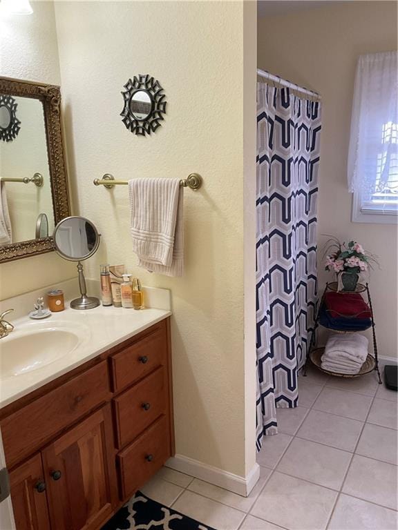 full bath featuring vanity, tile patterned floors, baseboards, and a shower with shower curtain