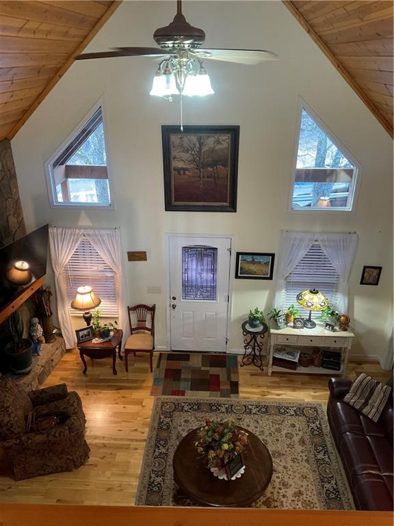 foyer entrance with high vaulted ceiling, wood ceiling, a ceiling fan, and wood finished floors