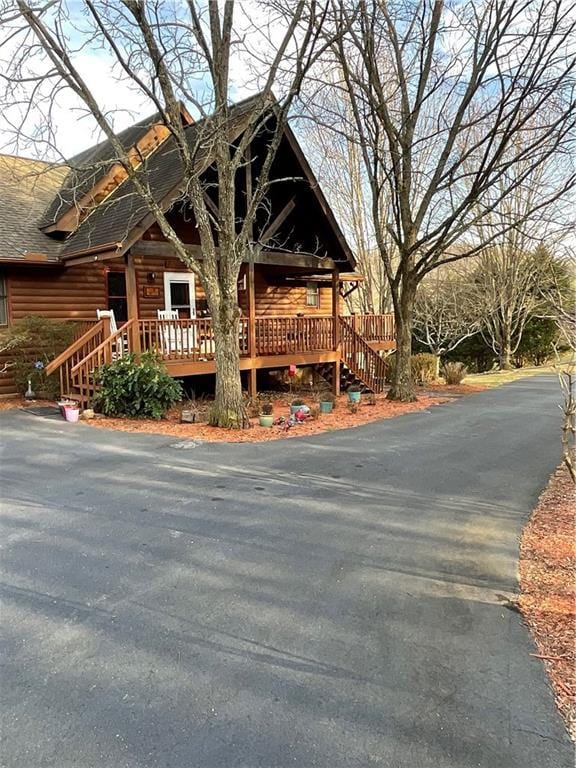 log-style house featuring a shingled roof