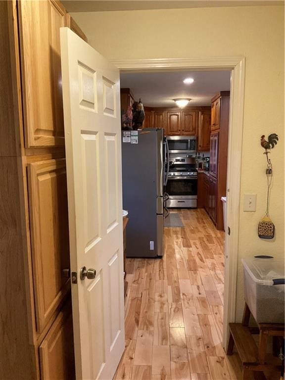 kitchen featuring brown cabinetry, light wood-style floors, and stainless steel appliances