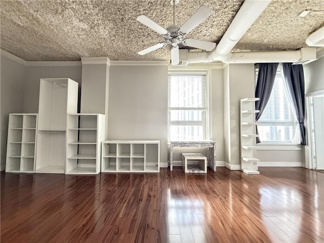 spare room featuring dark wood-type flooring, ceiling fan, a healthy amount of sunlight, and ornamental molding