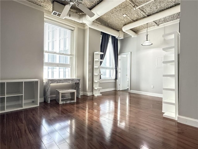 empty room featuring ceiling fan, dark hardwood / wood-style flooring, and plenty of natural light