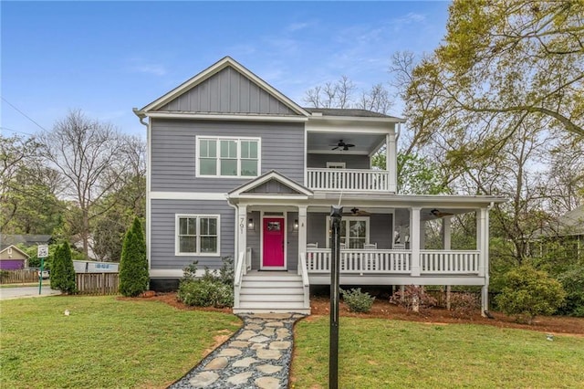 view of front facade featuring board and batten siding, a balcony, a front yard, covered porch, and a ceiling fan
