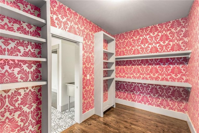 bathroom featuring wallpapered walls, baseboards, and wood finished floors