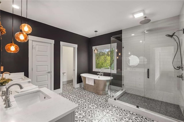 full bath featuring a shower stall, double vanity, a freestanding tub, and a sink