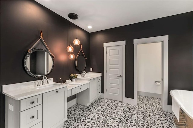 full bathroom featuring double vanity, a freestanding bath, baseboards, and a sink