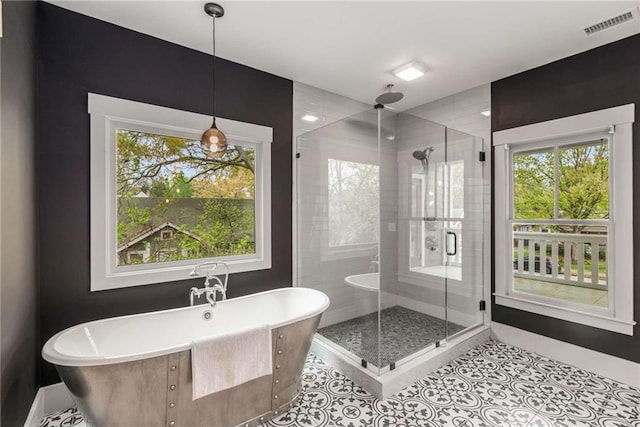 full bathroom featuring tile patterned flooring, baseboards, a soaking tub, a stall shower, and visible vents