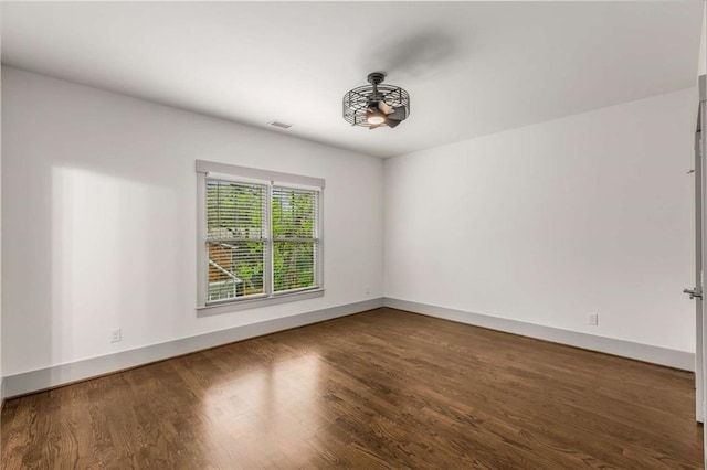 unfurnished room featuring baseboards and wood finished floors