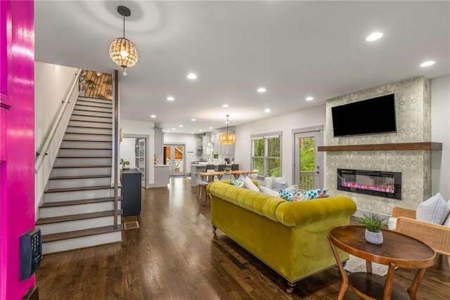 living room featuring a large fireplace, recessed lighting, and wood finished floors