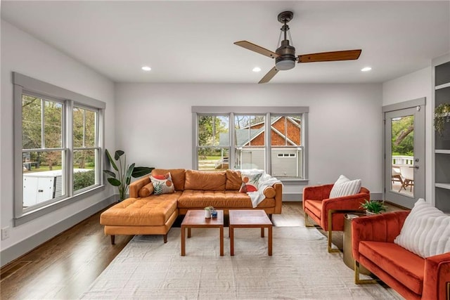 living room featuring baseboards, light wood-style flooring, recessed lighting, and a ceiling fan