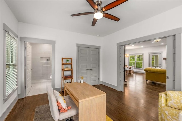 office area with baseboards, dark wood-type flooring, and a ceiling fan