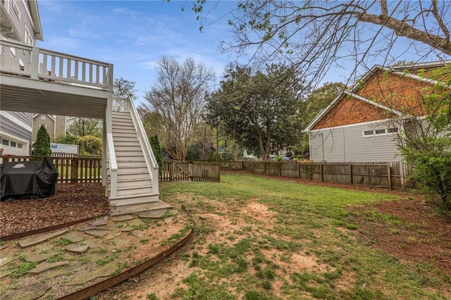 view of yard featuring stairs, a fenced backyard, and a deck