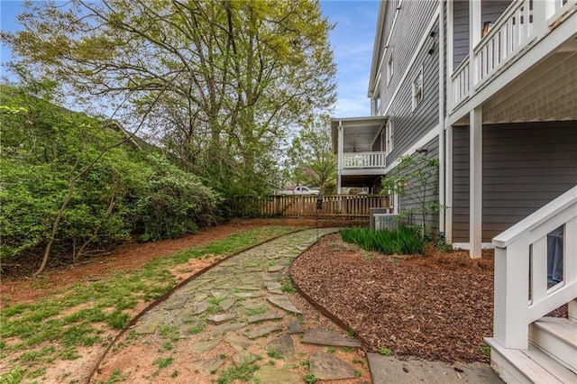 view of yard featuring a balcony and fence