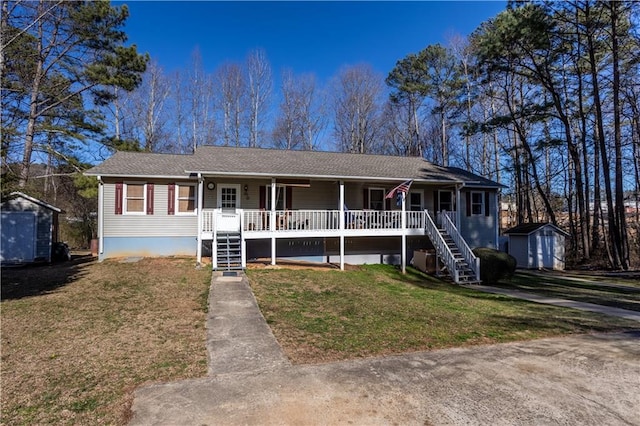 ranch-style house with an outbuilding, a storage unit, covered porch, a front yard, and stairs