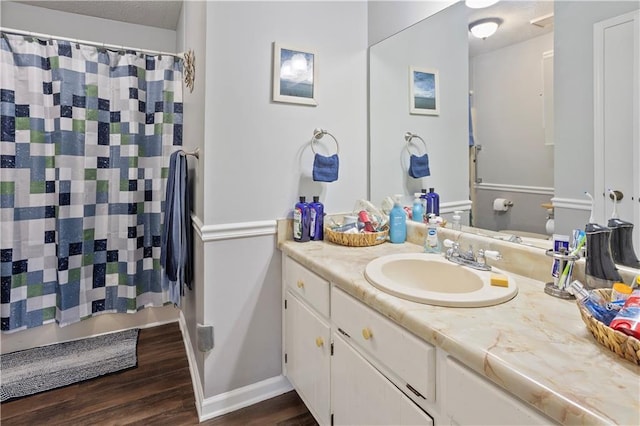 full bath with a shower with shower curtain, wood finished floors, and vanity