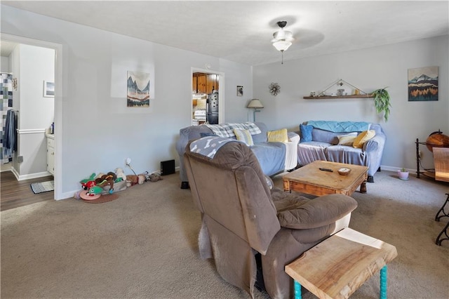 living area featuring a ceiling fan, carpet flooring, and baseboards