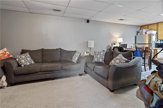 living room featuring a paneled ceiling, carpet, and visible vents