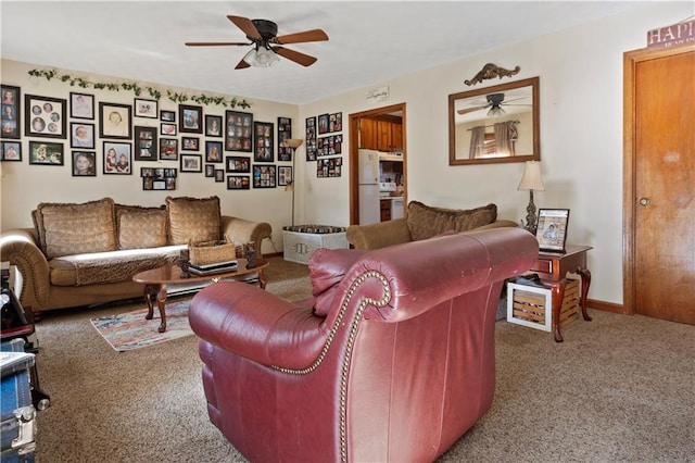 carpeted living area with a ceiling fan and baseboards