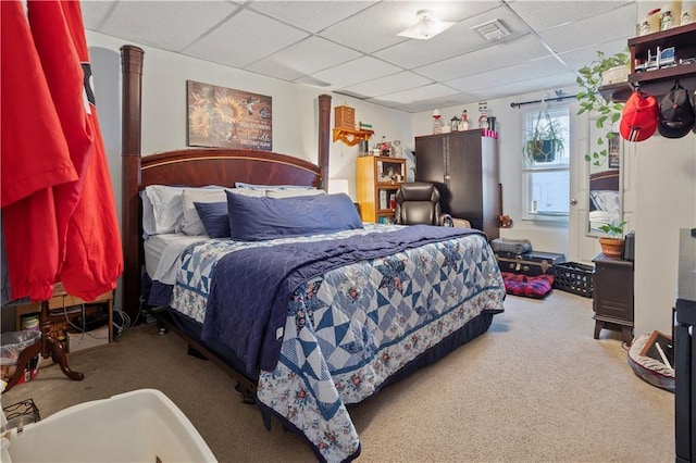 bedroom featuring carpet flooring, visible vents, and a drop ceiling