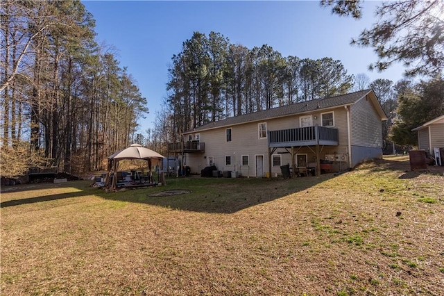 back of house featuring a lawn, a deck, and a gazebo