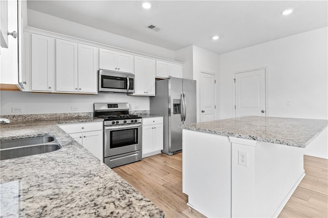 3660 Cattle Field Xing, Loganville, GA 30052 - kitchen with stainless steel appliances, white cabinets, light wood-style floors, light stone counters, and recessed lighting