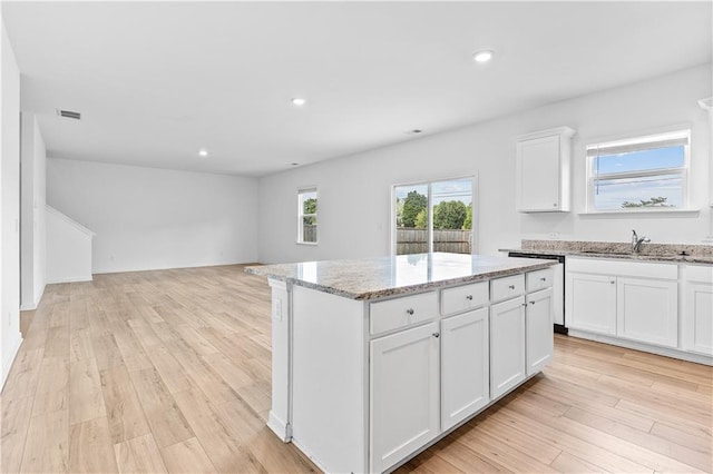3660 Cattle Field Xing, Loganville, GA 30052 - kitchen with dishwasher, open floor plan, a kitchen island, white cabinetry, and light stone counters