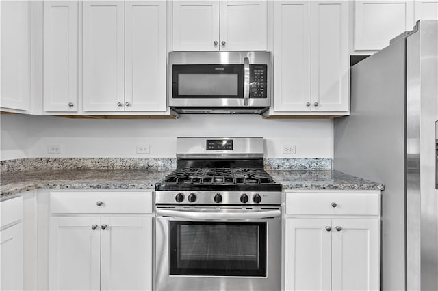 3660 Cattle Field Xing, Loganville, GA 30052 - kitchen with stainless steel appliances, white cabinetry, and light stone counters