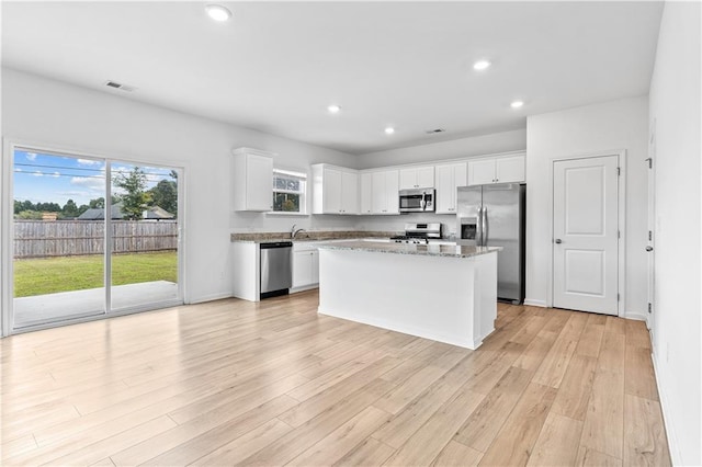 3660 Cattle Field Xing, Loganville, GA 30052 - kitchen featuring stainless steel appliances, white cabinets, light wood finished floors, recessed lighting, and a kitchen island