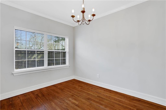 empty room featuring an inviting chandelier, hardwood / wood-style flooring, and crown molding