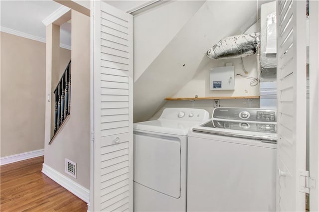 washroom with independent washer and dryer, crown molding, and light hardwood / wood-style flooring