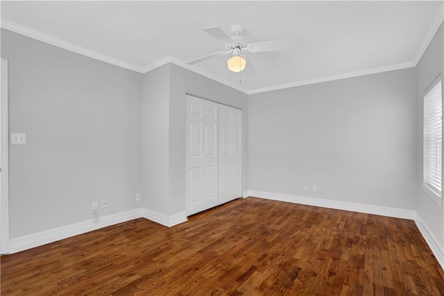 unfurnished bedroom featuring ornamental molding, dark wood-type flooring, ceiling fan, and a closet