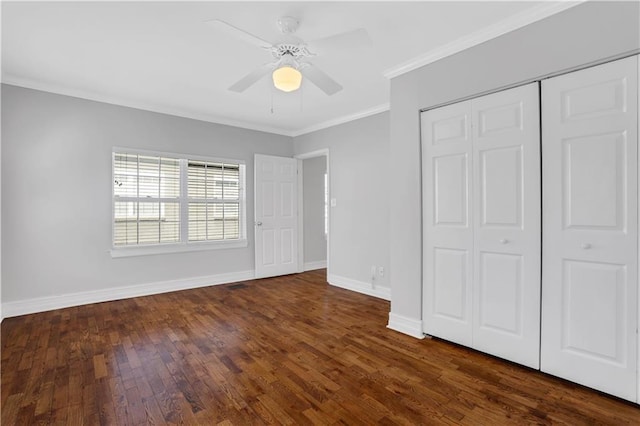 unfurnished bedroom featuring dark hardwood / wood-style flooring, crown molding, a closet, and ceiling fan