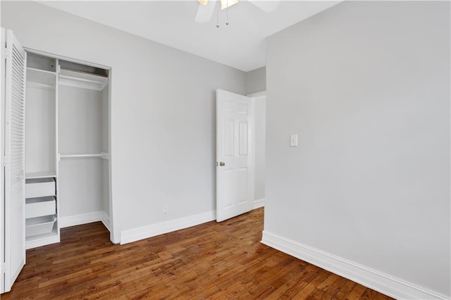 unfurnished bedroom with dark wood-type flooring, ceiling fan, and a closet