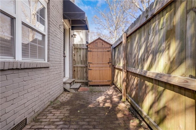 view of side of home with a shed and a patio