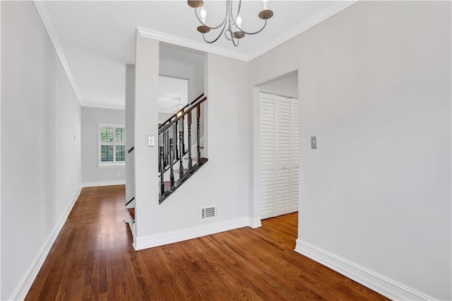 interior space featuring ornamental molding, a chandelier, and wood-type flooring