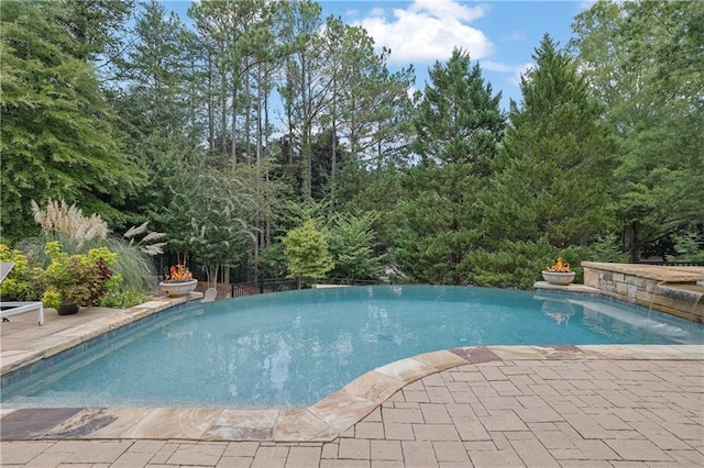 view of swimming pool with a patio and pool water feature