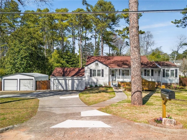 view of front of house featuring a garage, covered porch, and a front yard